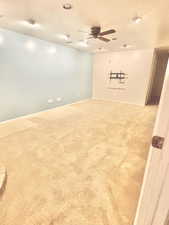 Carpeted empty room featuring a textured ceiling and ceiling fan