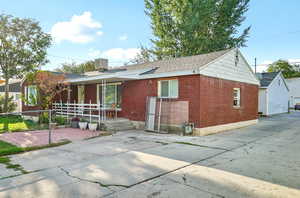View of front of house featuring brick siding and a shingled roof