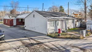 View of front of property featuring a fenced front yard and a shingled roof