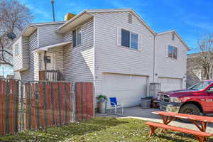 View of property exterior featuring a garage and fence