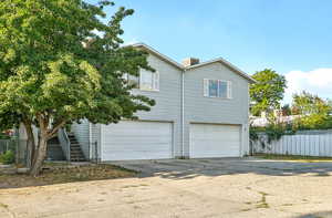 View of side of property with concrete driveway and an attached garage