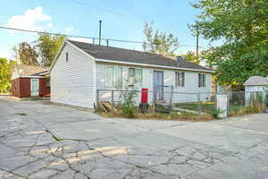 View of front of home featuring a shingled roof and concrete driveway