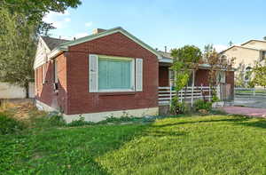 View of front of home with brick siding and a chimney
