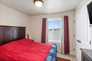Bedroom featuring light carpet and baseboards