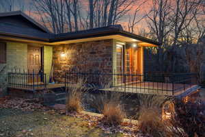 Property entrance featuring concrete block siding and a shingled roof