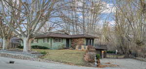 Single story home featuring a front yard, fence, brick siding, and driveway