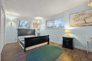 Bedroom with crown molding, wood finished floors, and baseboards
