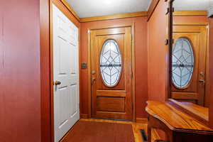 Entryway featuring visible vents, a textured ceiling, and wood finished floors