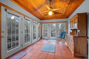 Sunroom with wooden ceiling, lofted ceiling, and ceiling fan