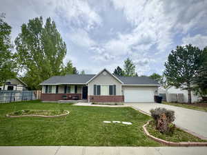 Single story home featuring brick siding, covered porch, concrete driveway, and a garage