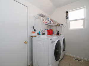 Laundry room featuring light tile patterned floors, baseboards, visible vents, laundry area, and washer and dryer