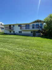 Rear view of property with a yard