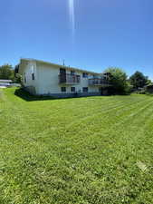 Rear view of house featuring a yard