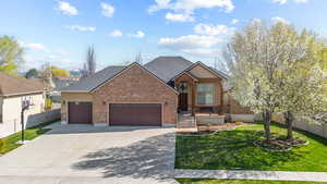 Traditional home with an attached garage, a front yard, fence, and driveway