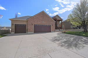View of front facade featuring fence, stucco siding, an attached garage, concrete driveway, and brick siding