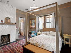 Main bedroom featuring visible vents, a large fireplace, and wood finished floors