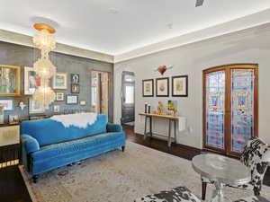 Living room featuring a notable chandelier, wood finished floors, arched walkways, and baseboards