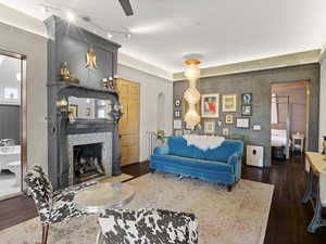 Living room with dark wood finished floors, a fireplace, and arched walkways