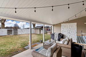 View of patio / terrace featuring a storage unit, fence, grilling area, an outdoor structure, and outdoor lounge area