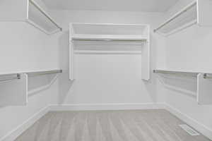 Walk in closet with carpet and visible vents