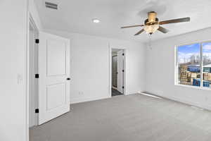 Unfurnished bedroom with visible vents, baseboards, carpet, and a textured ceiling