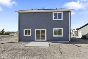 Back of property featuring stucco siding and a patio