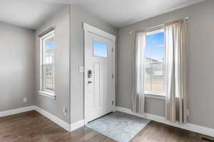 Foyer entrance featuring visible vents, baseboards, and wood finished floors
