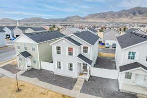 View of front facade featuring a mountain view, a residential view, a fenced backyard, and a shingled roof