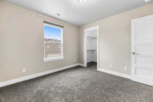 Unfurnished bedroom featuring visible vents, carpet floors, baseboards, and a spacious closet