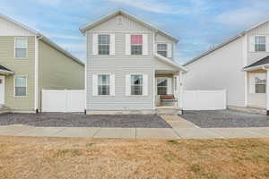 View of front facade with board and batten siding and fence