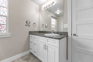 Bathroom with tile patterned floors, visible vents, baseboards, and vanity