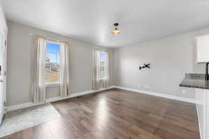 Unfurnished dining area with visible vents, baseboards, and wood finished floors
