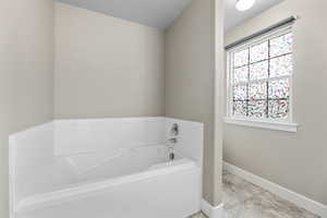 Master Bathroom Full bathroom with baseboards and a bath