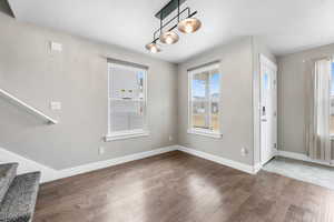Entryway with a wealth of natural light, baseboards, and wood finished floors