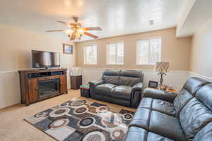 Living area with visible vents, light colored carpet, a textured ceiling, and ceiling fan