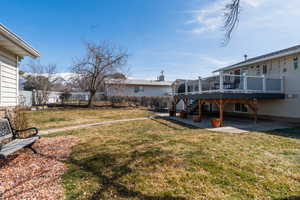 View of yard featuring a patio area, a wooden deck, and a fenced backyard