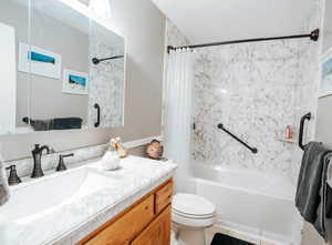 Full bath with shower / bath combination with curtain, toilet, and vanity