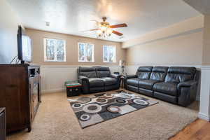 Living area featuring a ceiling fan, visible vents, and a textured ceiling