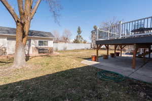 View of yard featuring a deck, a patio area, and fence