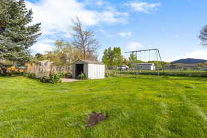 View of yard with fence and an outdoor structure