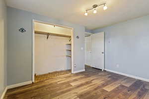 Unfurnished bedroom with baseboards, wood finished floors, and a closet