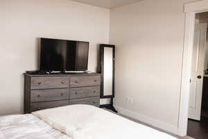 Bedroom with dark carpet and baseboards