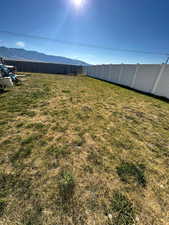 View of yard with a mountain view and fence