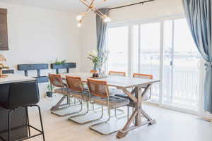 Dining room featuring a chandelier, plenty of natural light, light wood-style flooring, and visible vents