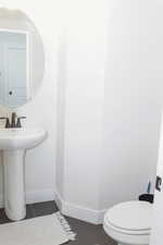 Bathroom with toilet, baseboards, and a sink