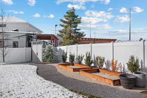 View of yard featuring a pergola, a fenced backyard, and a garden