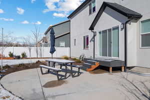 Back of property with a patio area, outdoor dining space, stucco siding, and fence
