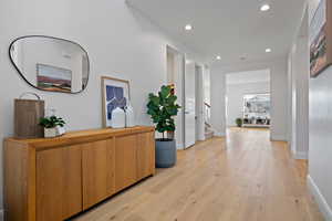 Hall featuring stairway, light wood-style flooring, recessed lighting, and baseboards