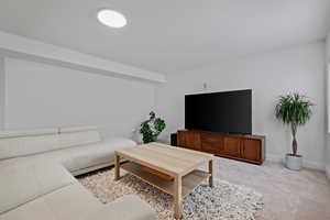 Living room featuring light colored carpet and baseboards