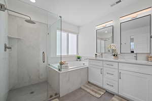 Full bath featuring a marble finish shower, visible vents, a bath, and double vanity
